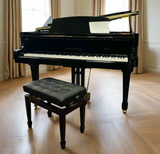 Sandner SG-151 Grand Piano with polished black finish and a piano stool in front. Set in a bright room