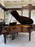 A Yamaha GB1 Disklavier Enspire ST Grand Piano with the lid open, showing the interior of the piano and the keyboard. The piano is placed in a showroom setting with a bench in front.